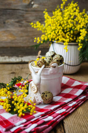 Easter time, Hand decorated Easter Eggs and speckled birds eggs in straw with a branch of colorful...