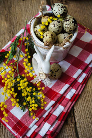 Easter time, Hand decorated Easter Eggs and speckled birds eggs in straw with a branch of colorful...