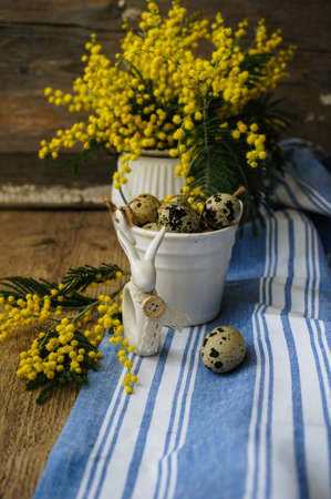 Easter time, Hand decorated Easter Eggs and speckled birds eggs in straw with a branch of colorful...