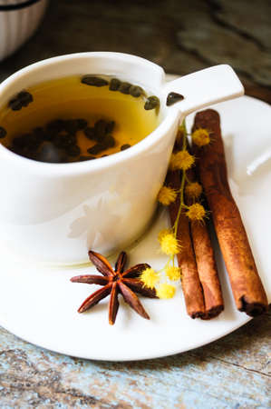 Glass cup with tea and blooming yellow mimosa with good morning note on wooden backgroundの写真素材