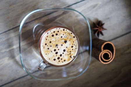 First spring flowers of violets and cup of coffee on the old wooden tableの写真素材