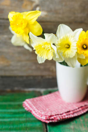 Spring flowers of daffodil on the old wooden tableの写真素材