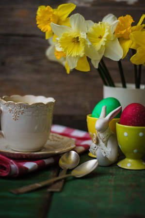 Cup of coffee, easter eggs and bunny on the old wooden tableの写真素材