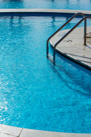 blue swimming pool with teak wood flooring stripes summer vacationの写真素材