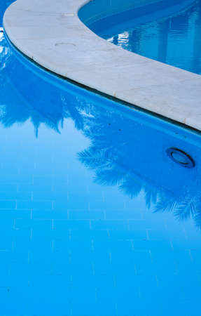 blue swimming pool with teak wood flooring stripes summer vacationの写真素材