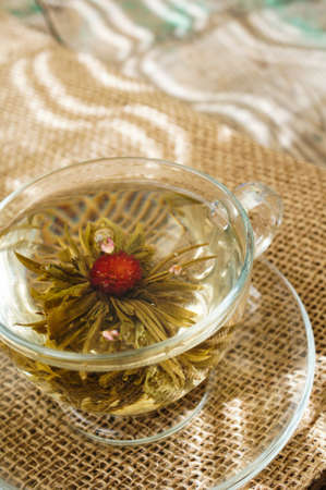 Exotic green tea with flowers in glass teapot on bright backgroundの写真素材