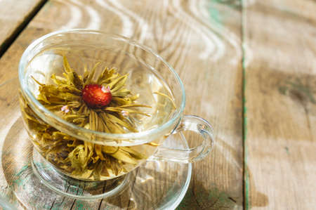 Exotic green tea with flowers in glass teapot on bright backgroundの写真素材