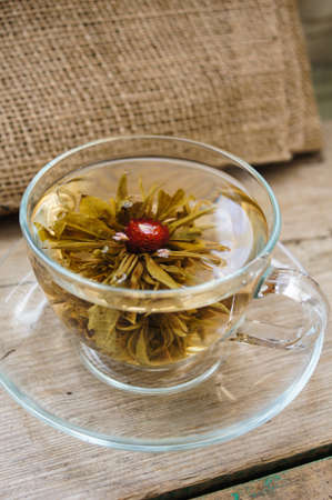 Exotic green tea with flowers in glass teapot on bright backgroundの写真素材