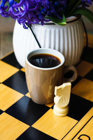 Cup of coffee on the chess board and first spring flowers Scyllaの写真素材