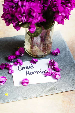 First spring flowers on the table with good morning note
