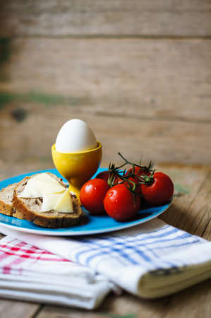 Healthy breakast with eggs and ripe cherry tomatoes on the bright napkinの写真素材