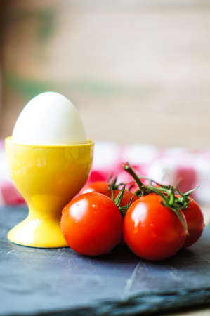 Healthy breakast with eggs and ripe cherry tomatoes on the bright napkinの写真素材