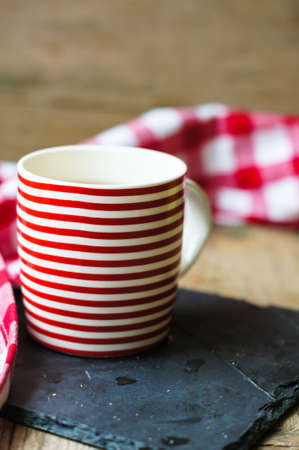 Red striped cup of tea with lemon and red napkinの写真素材