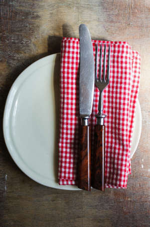 Table Setting with napkin and silverware on wooden table