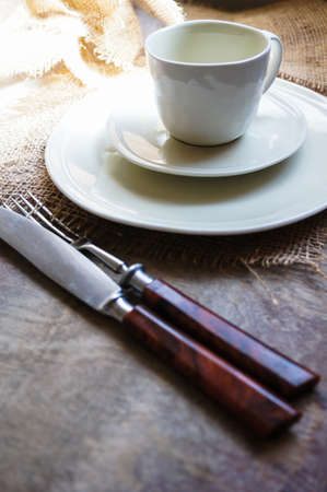Table Setting with napkin and silverware on wooden table