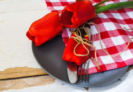 Red tulips with table set on a napkins, rusticの写真素材