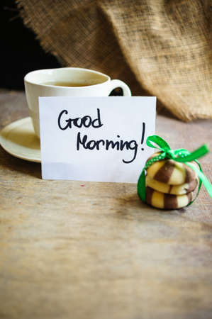 Cup of green tea, Good morning note and cookies on the tableの写真素材