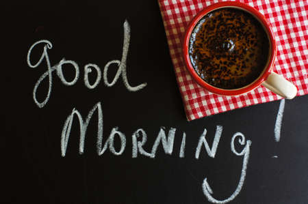 Cup of coffee with red sticks on the old table in the morningの写真素材