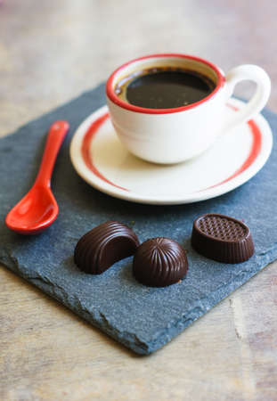 Cup of coffee with red sticks on the old table in the morningの写真素材