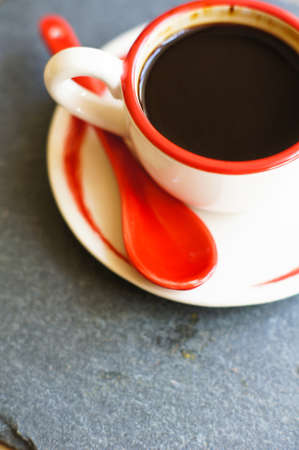 Cup of coffee with red sticks on the old table in the morningの写真素材
