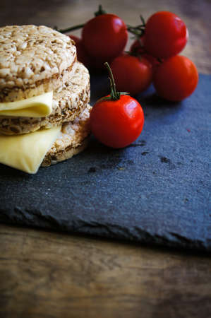 Healthy food, diet bread, cheese and cherry tomatoes on the rustic tableの写真素材