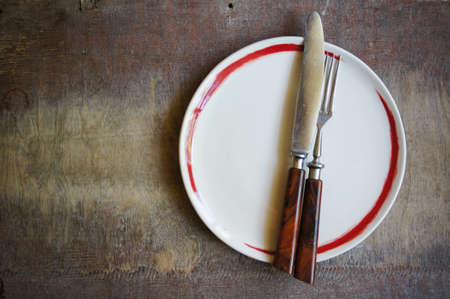 Plate and silverware on the old wooden table with burlap and napkinの写真素材