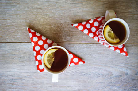 Red tea cup with tea and lemon on the old wooden background with noteの写真素材