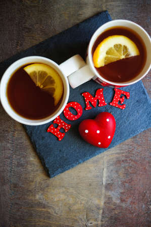 Red tea cup with tea and lemon on the old wooden background with noteの写真素材
