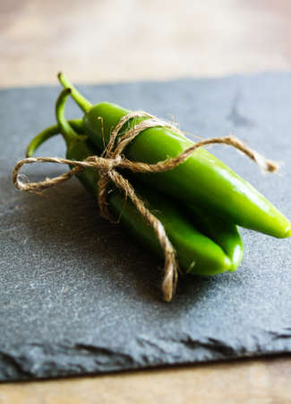 closeup green chilli peppers and different types of peppercornsの写真素材