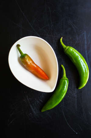closeup green chilli peppers and different types of peppercornsの写真素材