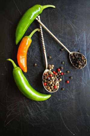 closeup green chilli peppers and different types of peppercornsの写真素材