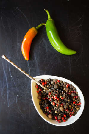 closeup green chilli peppers and different types of peppercornsの写真素材