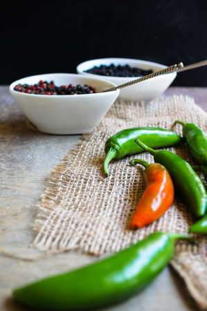 closeup green chilli peppers and different types of peppercornsの写真素材