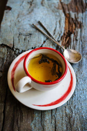 Cup of green tea and Home word on the old wooden background