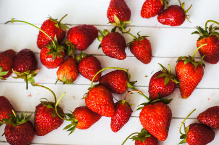 Fresh strawberries and white lilac flowers on the old wooden tableの写真素材