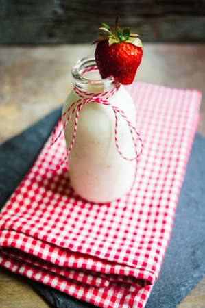 Strawberries yogurt and fresh fruits on the rustic kitchenの写真素材