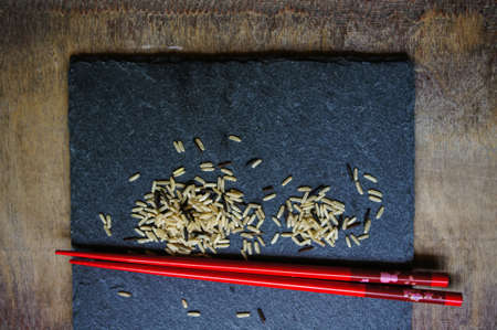 wild rice in ceramic bowl and chopsicks on wooden background