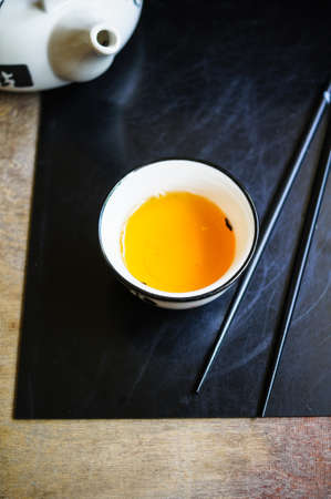 chopsticks and tea cup on rustic wooden tableの写真素材