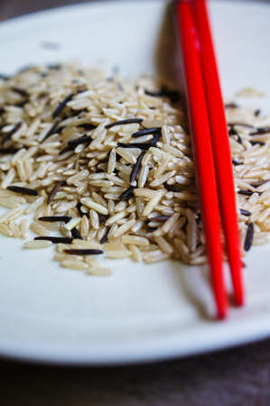 wild rice in ceramic bowl and chopsicks on wooden backgroundの写真素材