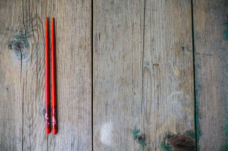Red chopsticks on the rustic tableの写真素材