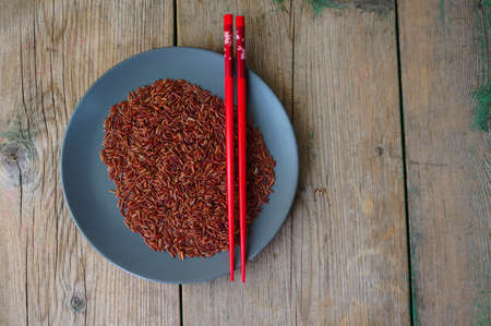 wild rice in ceramic bowl and chopsticks on wooden backgroundの写真素材
