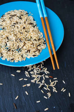 wild rice in ceramic bowl and chopsticks on wooden backgroundの写真素材