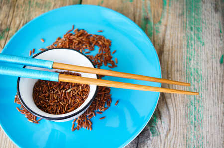 wild rice in ceramic bowl and chopsticks on wooden backgroundの写真素材