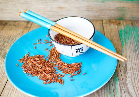 wild rice in ceramic bowl and chopsticks on wooden backgroundの写真素材