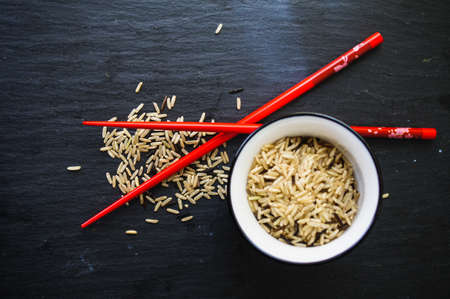 wild rice in ceramic bowl and chopsticks on wooden backgroundの写真素材