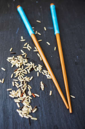 wild rice in ceramic bowl and chopsticks on wooden backgroundの写真素材