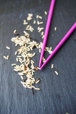 wild rice in ceramic bowl and chopsticks on wooden backgroundの写真素材