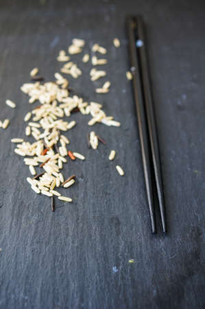 wild rice in ceramic bowl and chopsticks on wooden backgroundの写真素材