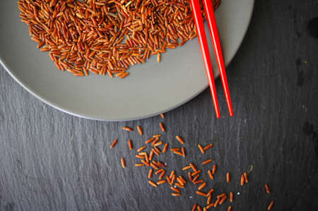 wild rice in ceramic bowl and chopsticks on wooden backgroundの写真素材