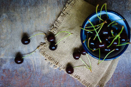 Ripe sweet cherries in the bowl on the rustic style old tableの写真素材